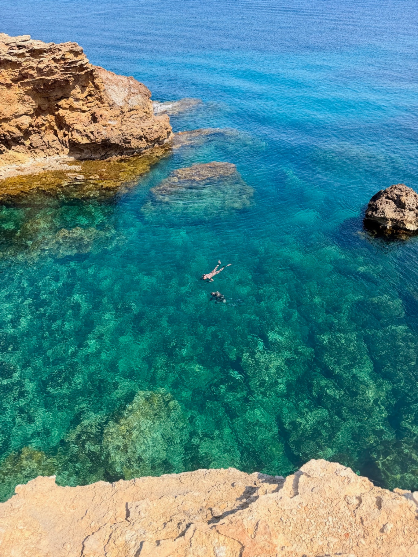 Snorkellers above crystal-clear reef in a hidden cove