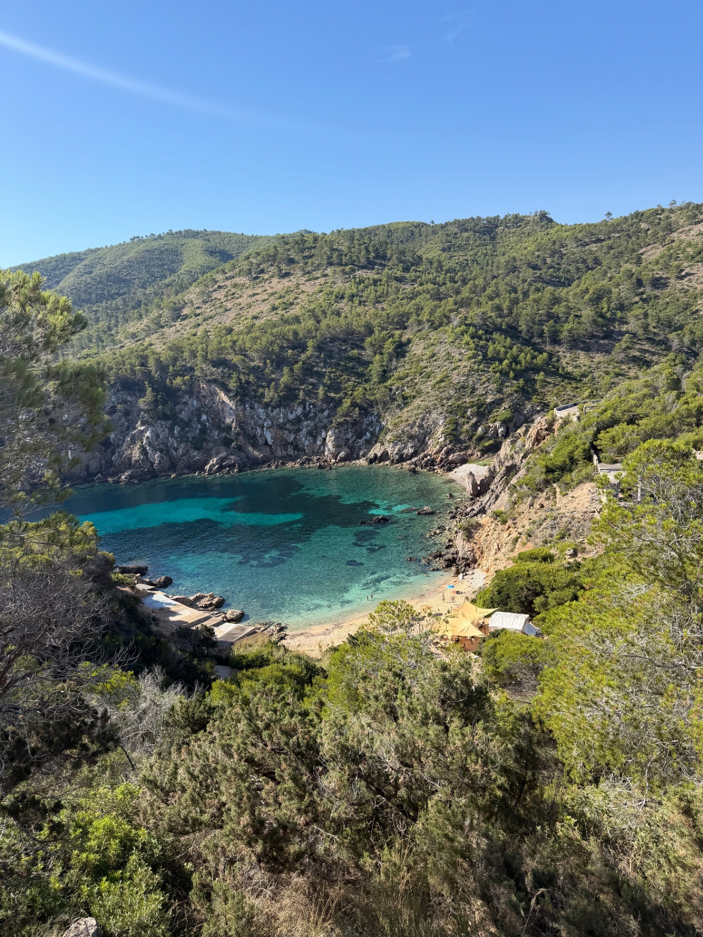 Tower of Light, hidden cove with turquoise water and golden beach tent from above