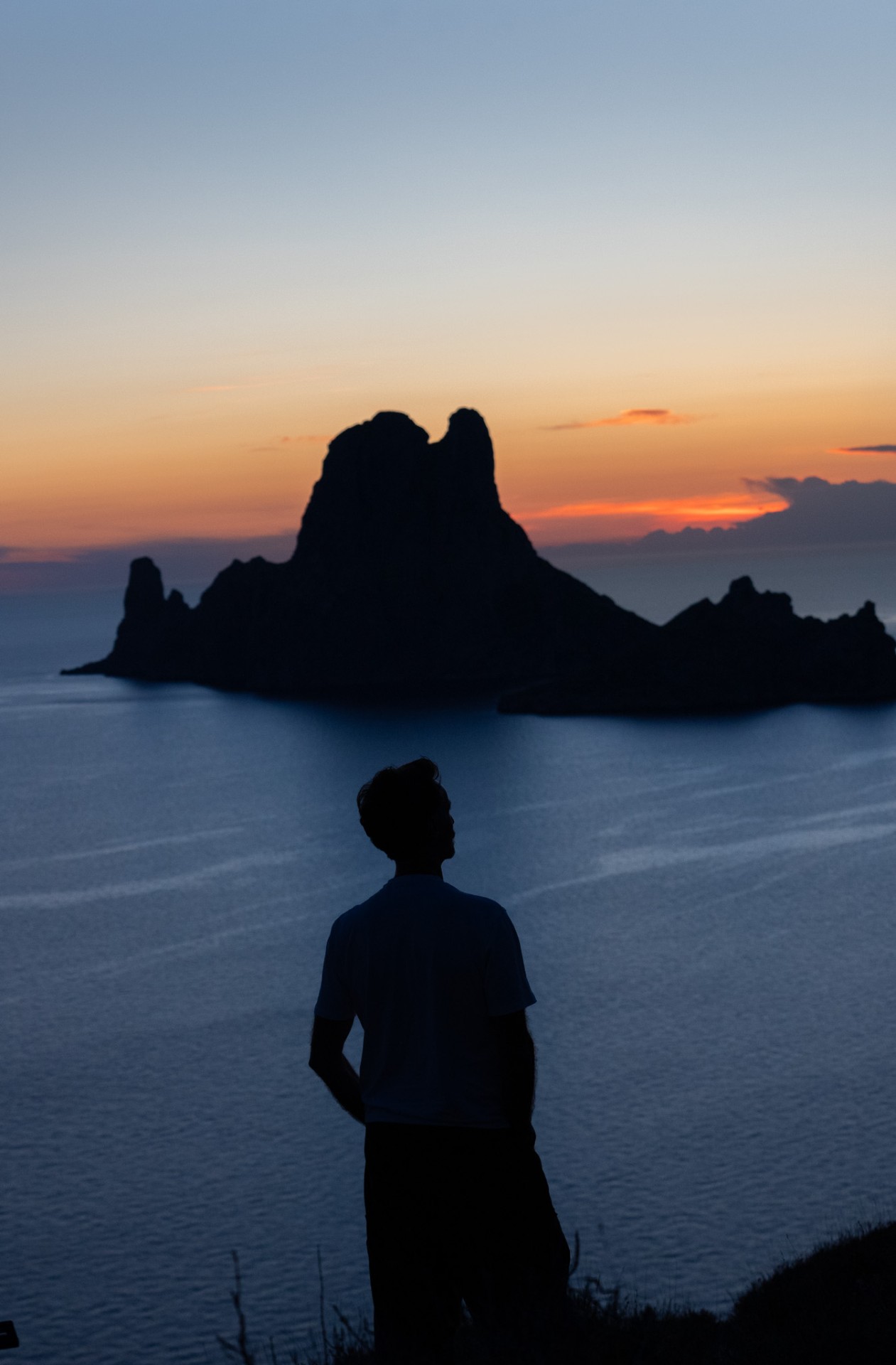 Woweee Sunset, lone hiker facing Es Vedrà at dusk
