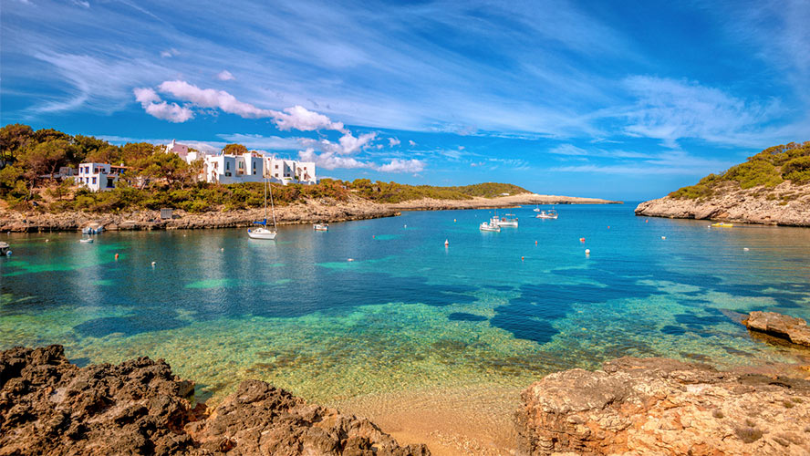 Tower of Light, turquoise cove with boats and whitewashed houses above the bay