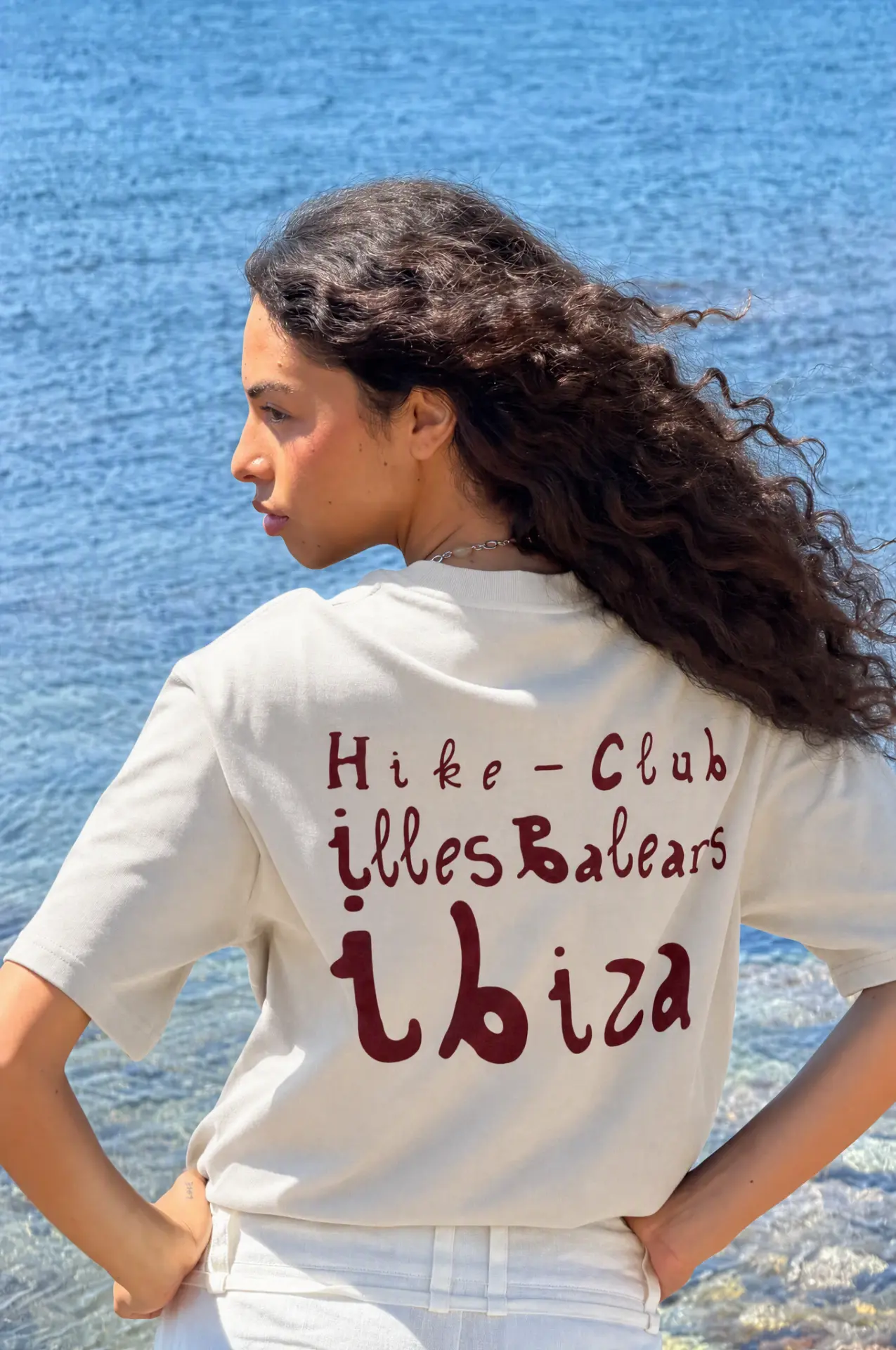 Woman wearing the off-white Hike Club Ibiza T-shirt with red print
