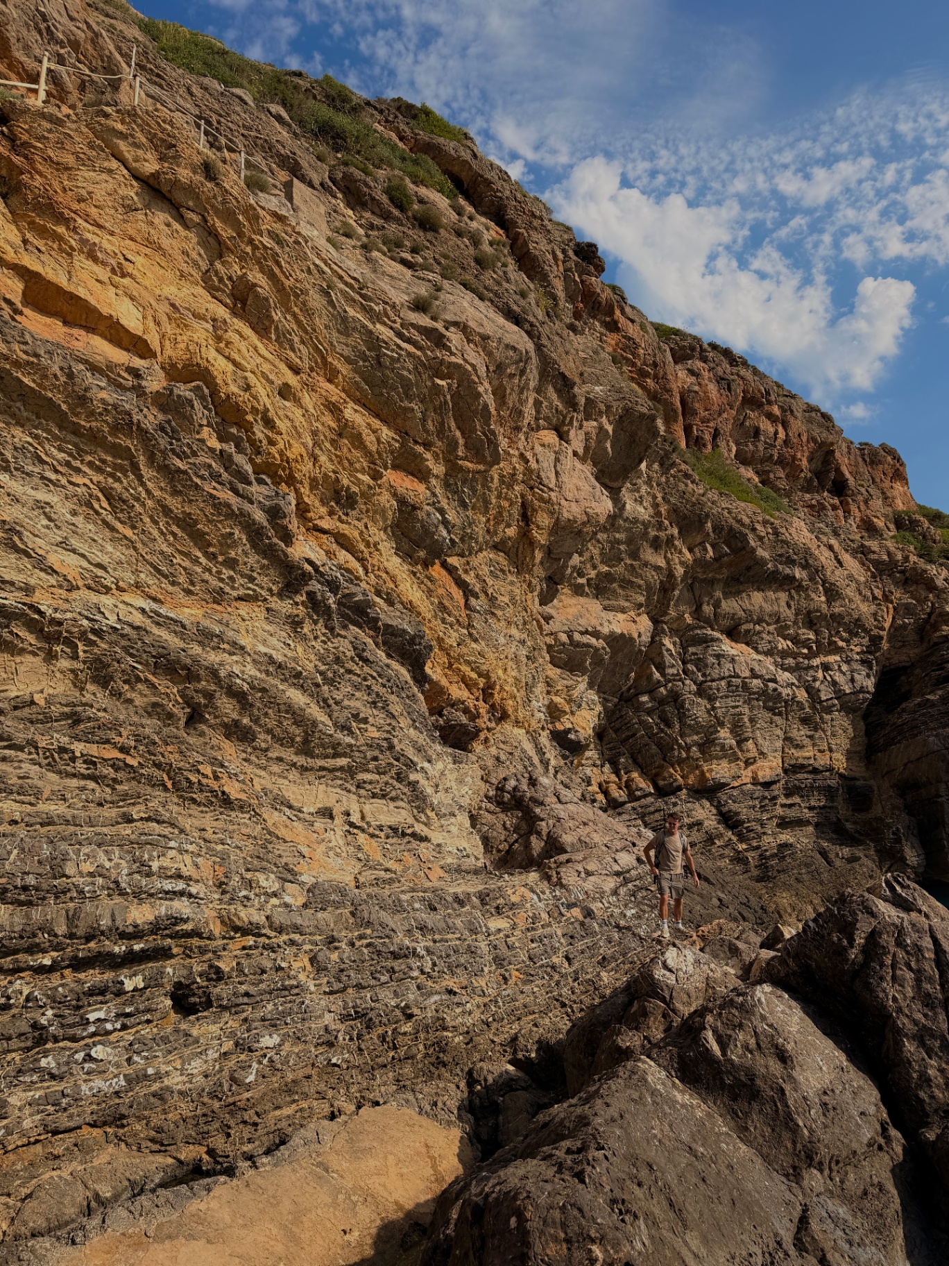 Towering layered cliff wall above the trail