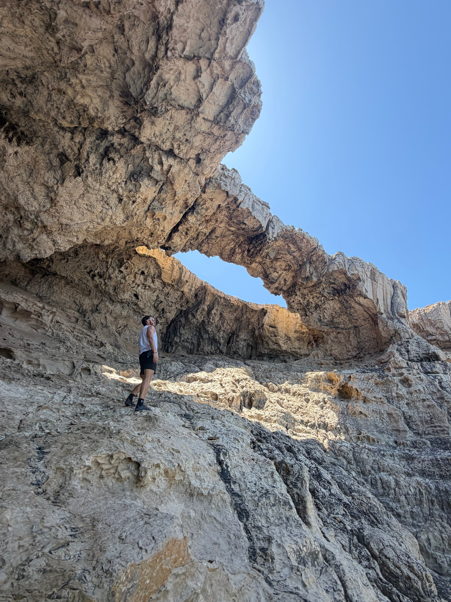 Jurassic Cave, hiker beneath a huge natural rock arch