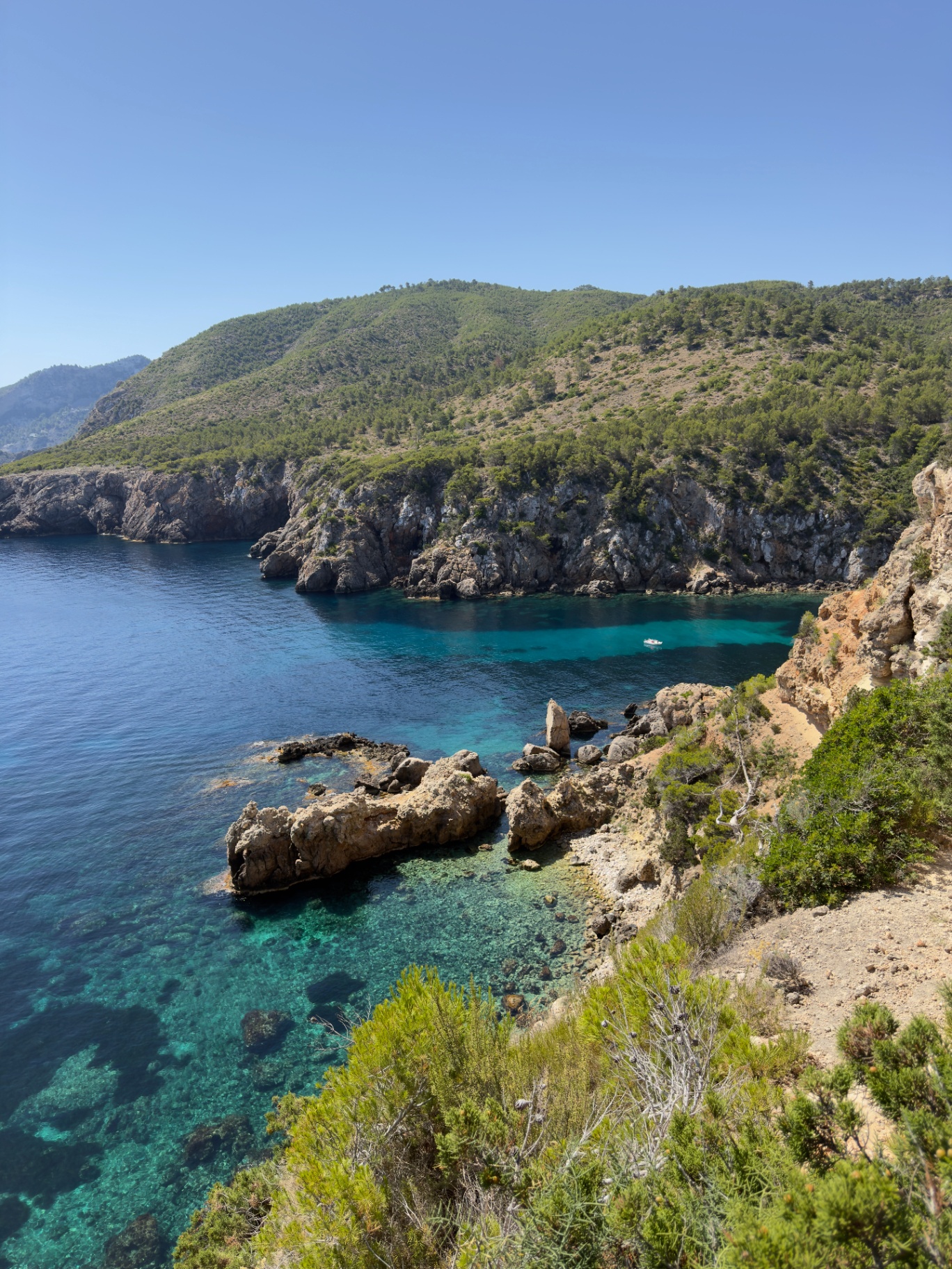 Tower of Light, dramatic rocky coastline with crystal-clear emerald water