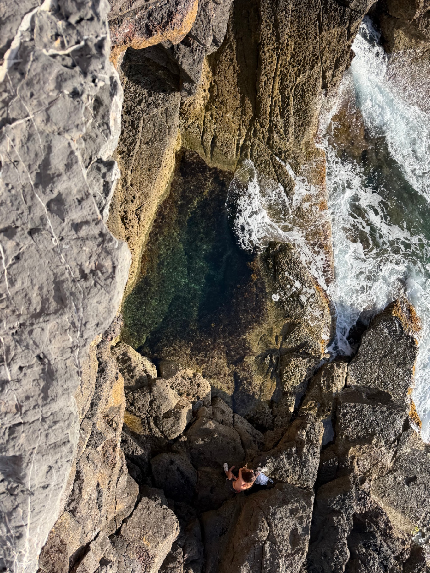 Aerial view of a turquoise canyon pool carved into rocky cliffs, Island Canyons