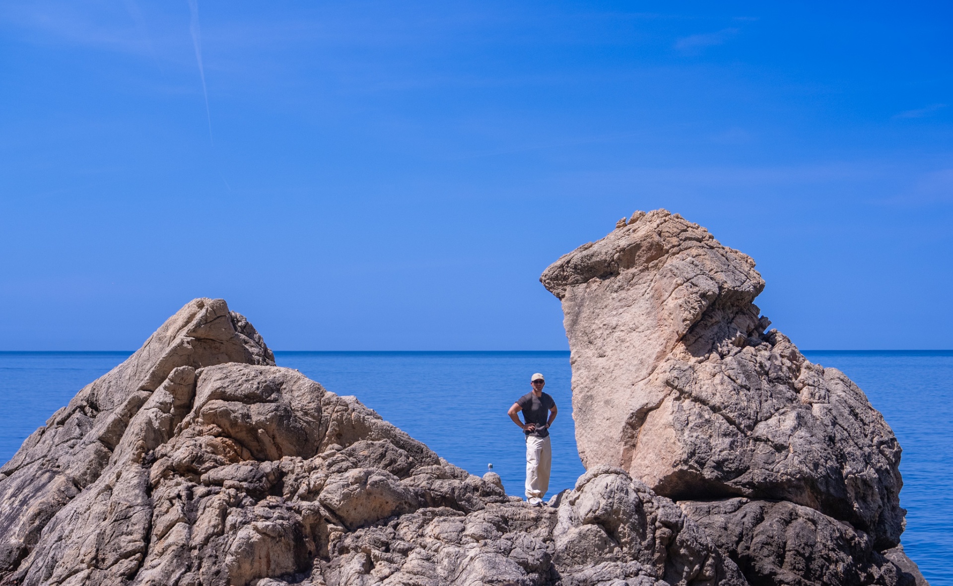 Dreamscape, hiker standing between dramatic limestone formations above the sea