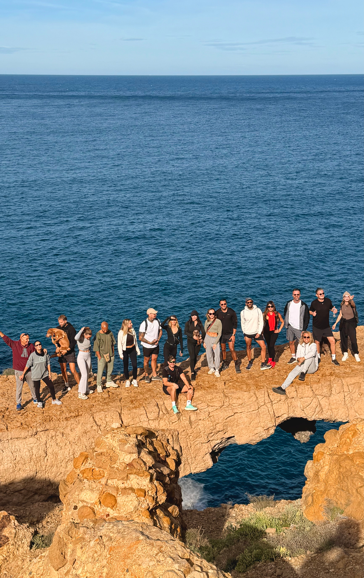 Jurassic Cave, group on the cliff edge above the deep blue Mediterranean