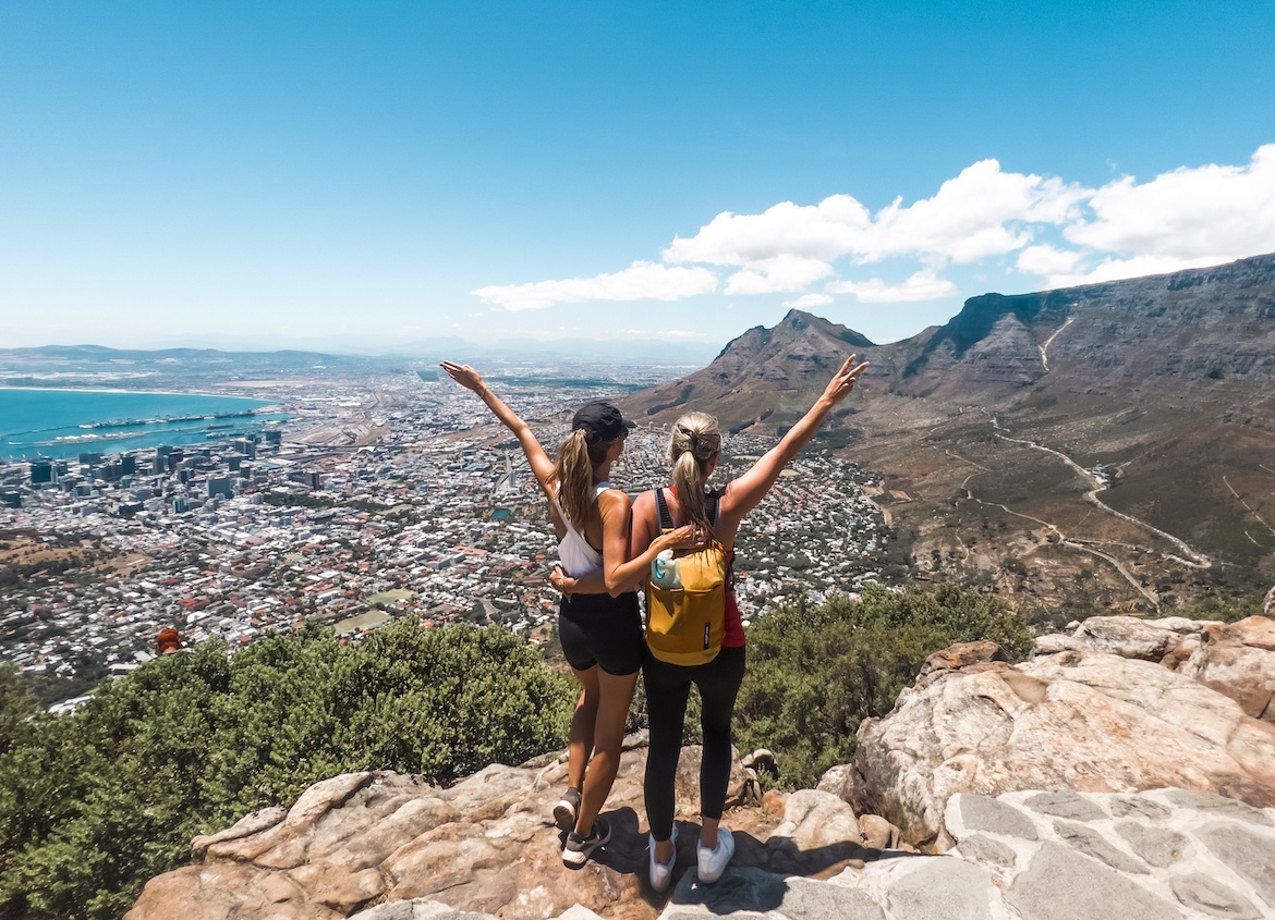 Hikers celebrating at the top with the city below